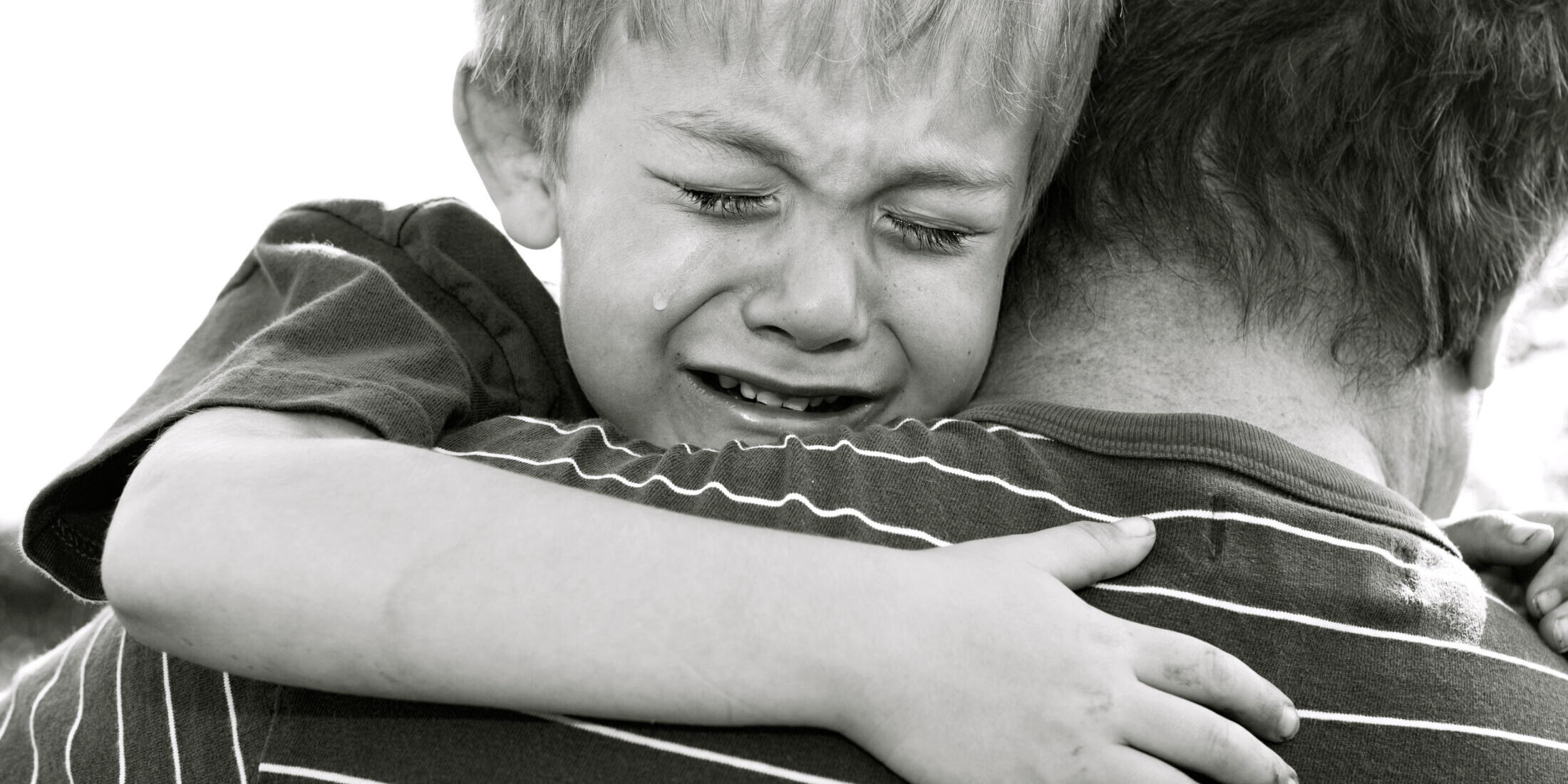 Crying Boy being comforted by his father